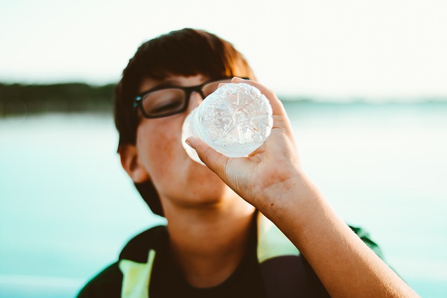 A man takes a break to hydrate after an exercise therapy session, highlighting the importance of hydration in physiotherapy and rehabilitation.