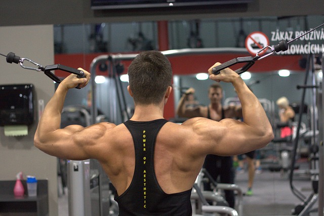 A man performs weightlifting exercises in a gym setting, showcasing strength and conditioning as part of his physiotherapy rehabilitation program.